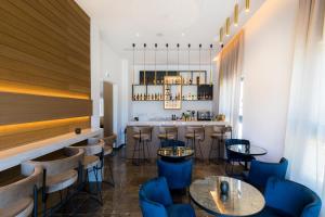 un restaurant avec des chaises bleues et un bar dans l'établissement The Quality Lodge - Self Check-in, à Oroklini