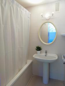 a white bathroom with a sink and a mirror at Trill Mirasol C primera linea mar L'Estartit in L'Estartit