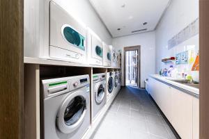 a laundry room with washing machines and a sink at Atour S Hotel Binhe Times Shenzhen in Shenzhen