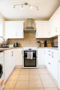 a kitchen with white cabinets and an oven at Penny's Place in Plymouth