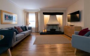 a living room with a couch and a fireplace at Charnwood Guest House in Bracknell