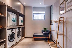 a small laundry room with a washer and dryer at Atour Light Hotel Chunxi Road Subway Station Taikoo Li Chengdu in Chengdu