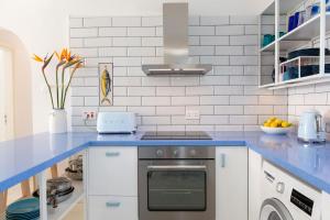 a white kitchen with a blue counter top at Zima Blue in Zygi