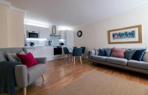 a living room with a couch and a kitchen at Charnwood Guest House in Bracknell