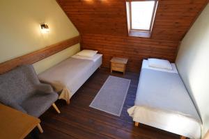 a attic room with two beds and a chair at Kütioru puhkekeskus in Koloreino