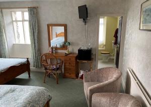 1 dormitorio con cama, silla y vestidor en Ullathorns Farm en Kirkby Lonsdale
