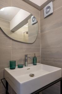 a bathroom with a white sink and a mirror at Nomado Residence with gym in Istanbul