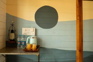 a room with a table with drinks on a wall at Shambho Retreat in Canacona