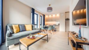 a living room with a couch and a table at Apartamenty Sun & Snow Bank Polski in Gdynia