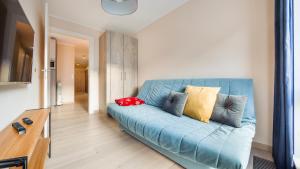 a blue couch sitting in a living room at Apartamenty Sun & Snow Bank Polski in Gdynia