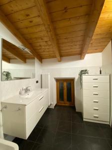 baño con lavabo blanco y techo de madera en LAKE HOUSE near Bellagio, en Lezzeno