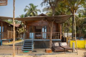 a tiny house on the beach with a porch at Shambho Retreat in Canacona