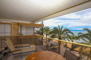 balcón con vistas al océano y a las palmeras en DIFFERENTFLATS Barcino, en Salou