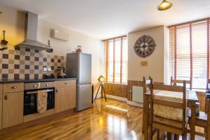 una cucina e una sala da pranzo con tavolo e frigorifero di Cornish Tin Mine Themed Apartment a St Austell Altre 8 foto