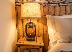 eine Lampe auf einem Nachttisch neben einem Bett in der Unterkunft Cornish Tin Mine Themed Apartment in St Austell
