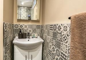 ein Bad mit einem Waschbecken und einem Spiegel in der Unterkunft Cornish Tin Mine Themed Apartment in St Austell