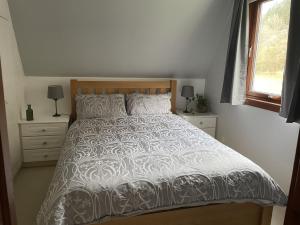 Caledonia Lodge في سبين بريدج: غرفة نوم بسرير لحاف أبيض ونافذة