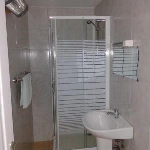 een badkamer met een douche, een wastafel en een toilet bij Hotel du Centre in Châlus