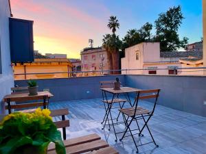 a patio with two tables and chairs on a roof at Dimora San Gregorio Luxury Rooms in Palermo
