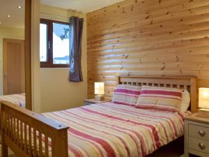 Кровать или кровати в номере Herons Log Cabin