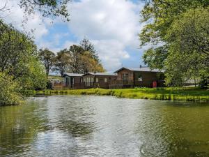 a view of a river with houses in the background at Herons Log Cabin in Rosebush