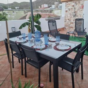 a table with chairs and plates of food on a patio at Santiago del Teide Apartman in Santiago del Teide