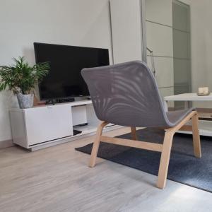 a chair sitting in a living room with a television at Santiago del Teide Apartman in Santiago del Teide