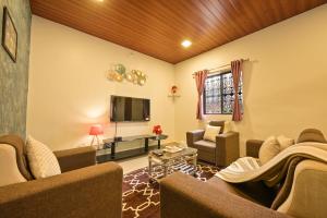 a living room with couches and a flat screen tv at Infinity Pool 2bhk Villa with valley view in Panchgani