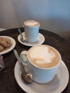 deux tasses de café sur des assiettes sur une table dans l'établissement El Espacio, à Junín