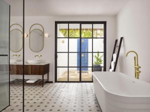 a bathroom with a tub and a sink at Villa Nautica Paradise Island Resort in Himmafushi