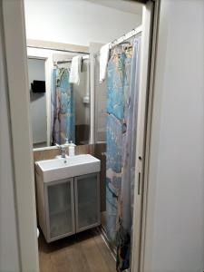 baño con lavabo y cortina de ducha en Blue House Napoli, en Nápoles