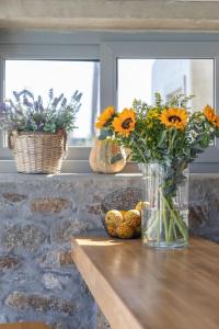 wazę wypełnioną słonecznikami siedzącą na stole w obiekcie Sea Wind Villas and Suites w mieście Tourlos
