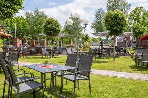un groupe de tables et de chaises dans un parc dans l'établissement Hotel Ripken, à Kirchhatten