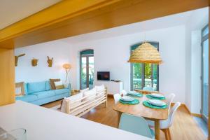 - un salon avec une table et un canapé bleu dans l'établissement Casa Verde Sal, à Alcácer do Sal