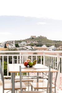 a table with a bowl of fruit on a balcony at Basiliki's Apartments in Archangelos