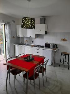 una cocina con mesa roja y sillas. en Cà gialla de Drignana, en Vernazza