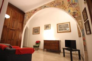 a living room with an archway with a tv and a couch at Case VR Holiday Il Giardino dei Glicini in Verona