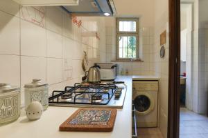 a kitchen with a stove and a washing machine at Case VR Holiday Il Giardino dei Glicini in Verona