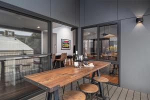 a dining room with a wooden table and chairs at Olsen Penthouse - Art House Townhouses in Bright