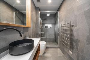 a bathroom with a sink and a toilet and a shower at Olsen Penthouse - Art House Townhouses in Bright +34 photos