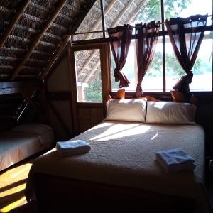 1 dormitorio con 1 cama en una habitación con ventana en River Spot Lodge home of the chocolate & coffe History center&river tours, en Tena