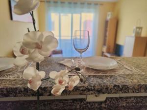 a table with a glass of wine and flowers on it at sol y mar in Puerto de Santiago +3 photos