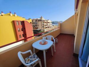 a small white table and chairs on a balcony at sol y mar in Puerto de Santiago
