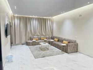 a living room with a couch and a table at سحاب تهلل السودة Sahab AL-Sodah in Suda