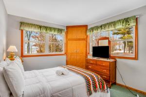 een slaapkamer met een bed, een tv en ramen bij Serenity on Castle Rock in Friendship