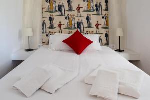 a bedroom with a white bed with a red pillow at Plaza de Santa Cruz in Seville