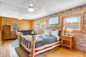 1 dormitorio con cama y pared de piedra en The Birdie Lodge, en Arkdale