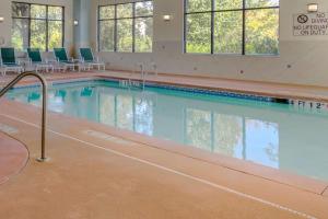 una piscina con sillas en un edificio en Comfort Suites Stockbridge Atlanta South, en Stockbridge