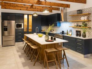 a kitchen with black cabinets and a large island with bar stools at Ludicks Farm in Montagu