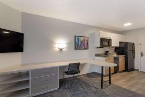 a kitchen with a desk and a table with a chair at MainStay Suites Omaha Old Mill in Omaha +12 photos